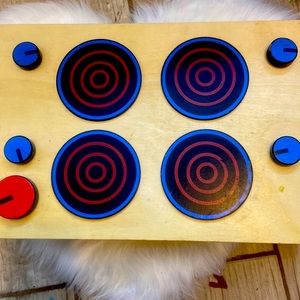 A kitchen toy oven with food and pots and spoons and cups